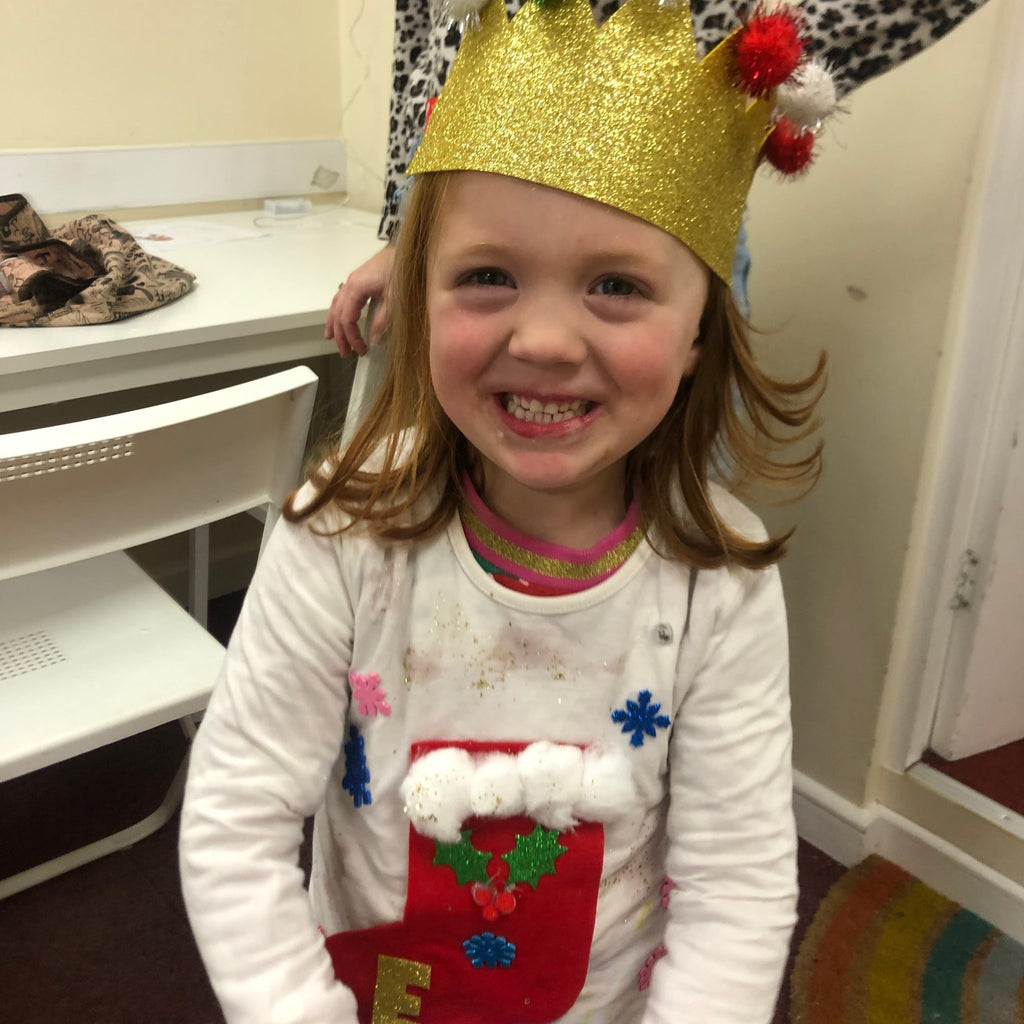 a little girl with christmas jumper with big red stocking and cotton wool top!