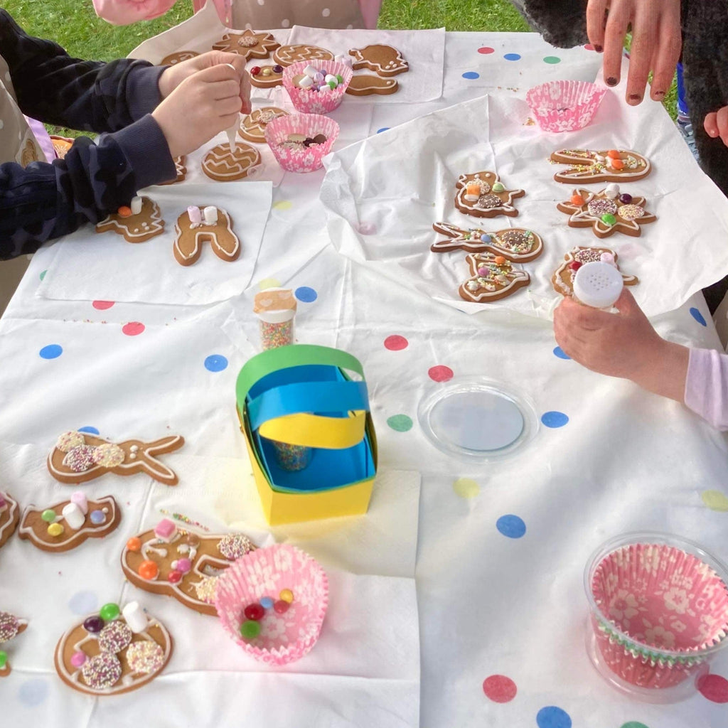 ginger bread decorating and pom stitch tassel cuppa and craft session.  Hands and sweets spread over the craft table.