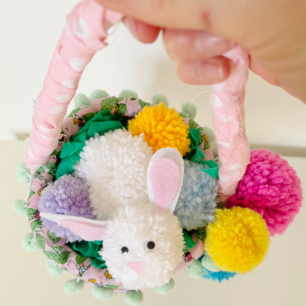Pom Pom spring bunny basket. Rope basket wrapped in patterned fabric with Pom pom decorations.