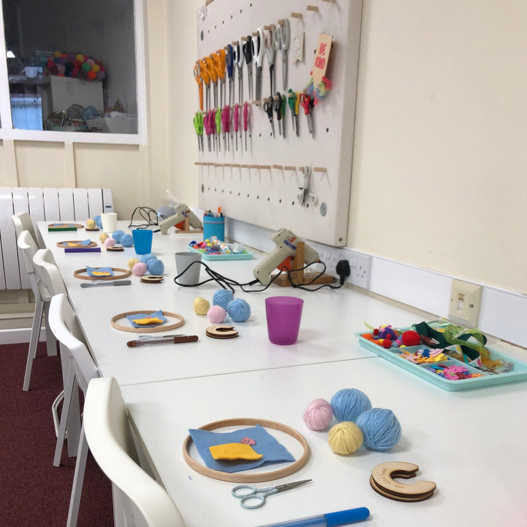 cross stitch all set up for a craft and cuppa session at pom stitch tassel. Embroidery hoop, wool, pom maker, felt, scissors and pen.