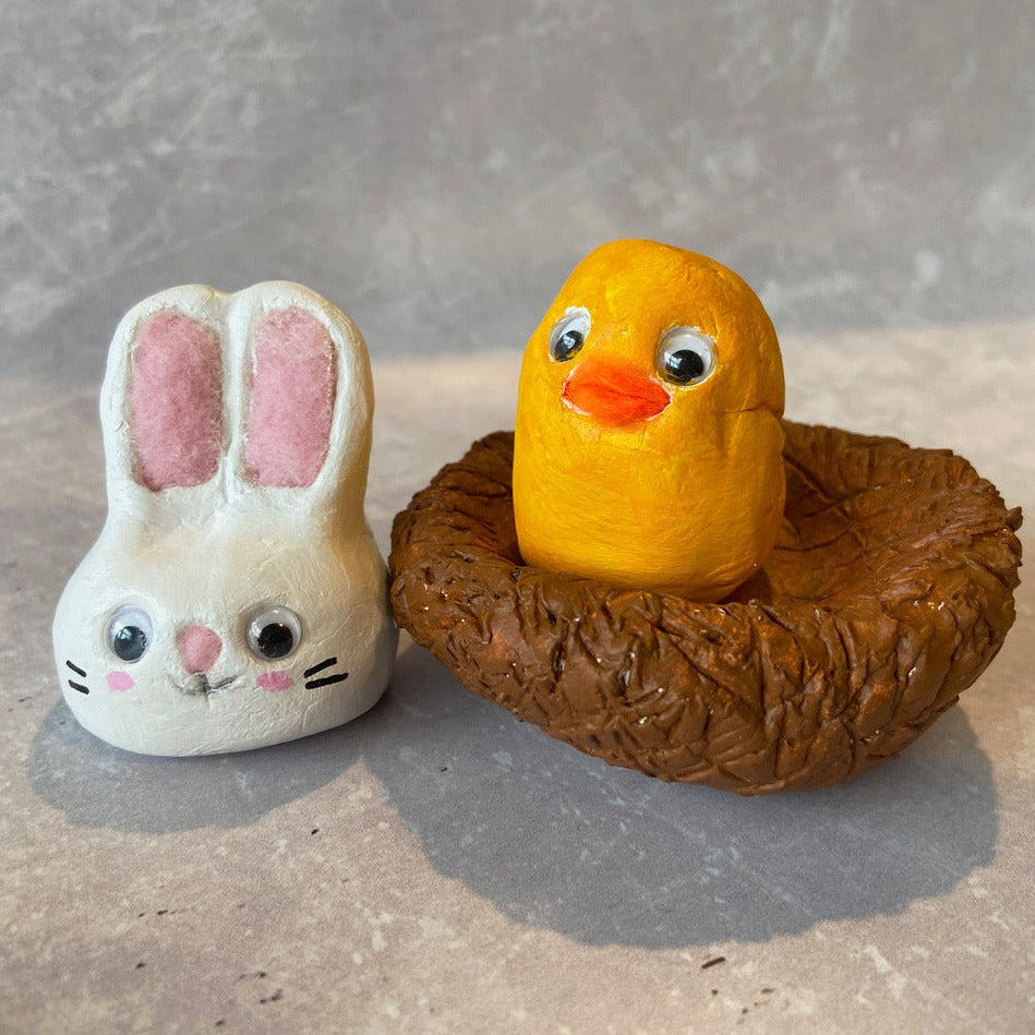 Easter workshop - create clay animals - bunny and chick in nest. Photo of both on grey background.