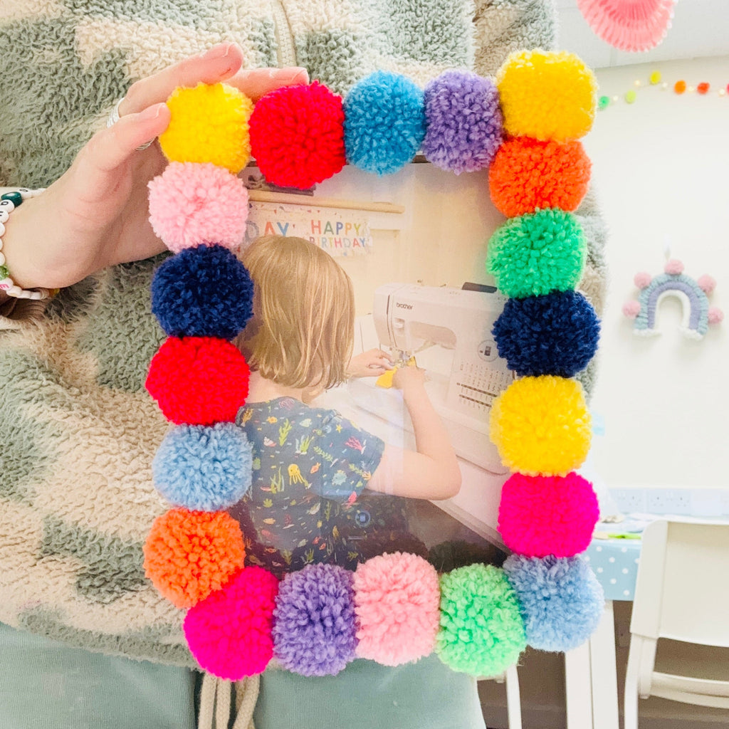 pom pom photo frame in hands in pom stitch tassel shop