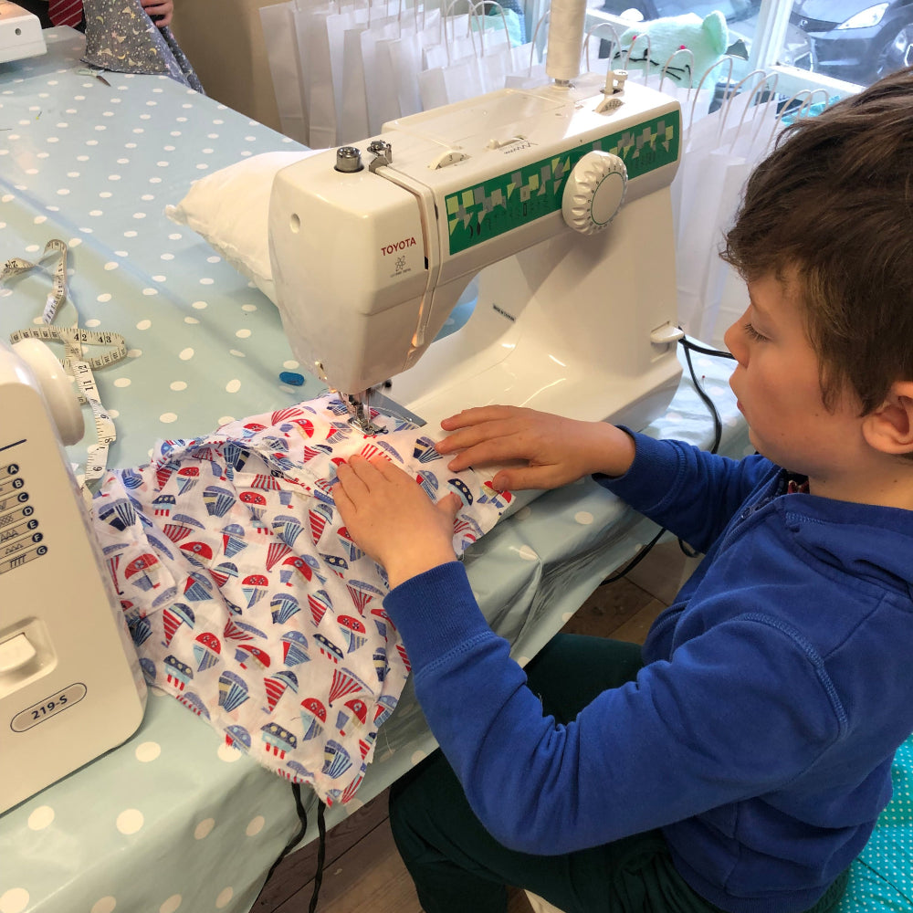 little boy sewing at pom stitch tassel hq - summer sewing club