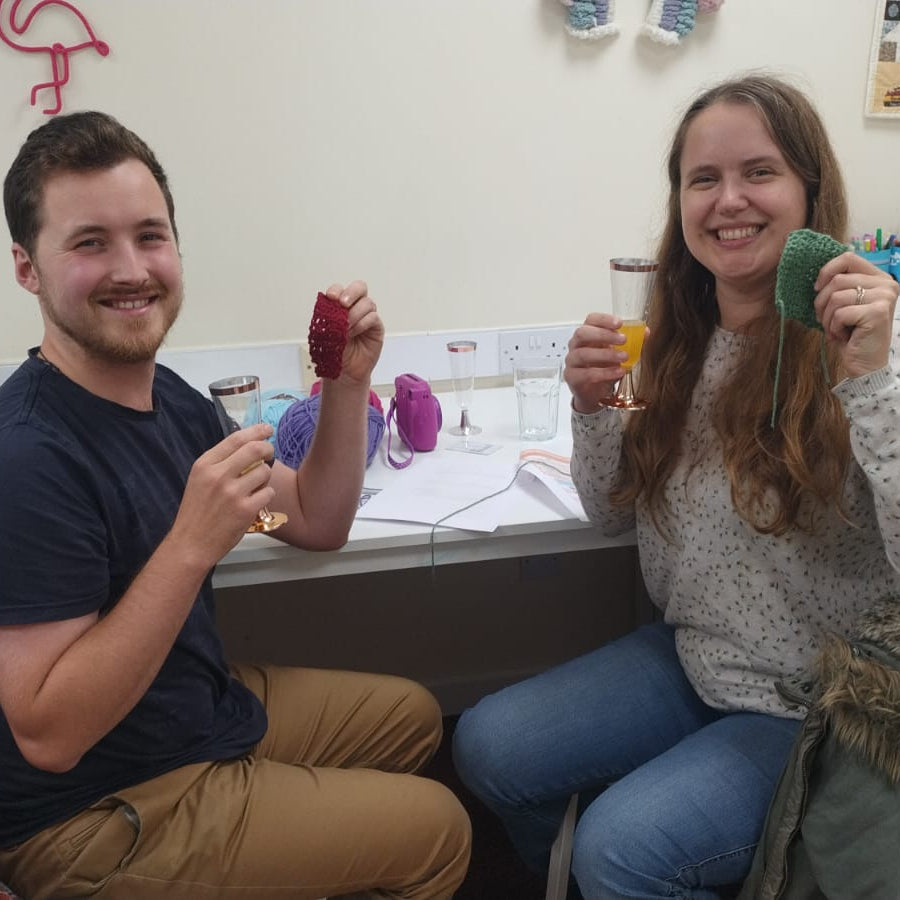 a couple crocheting with their cocktails