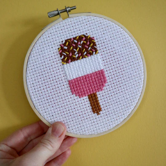 cross stitch fab lollipop in hoop on yellow background