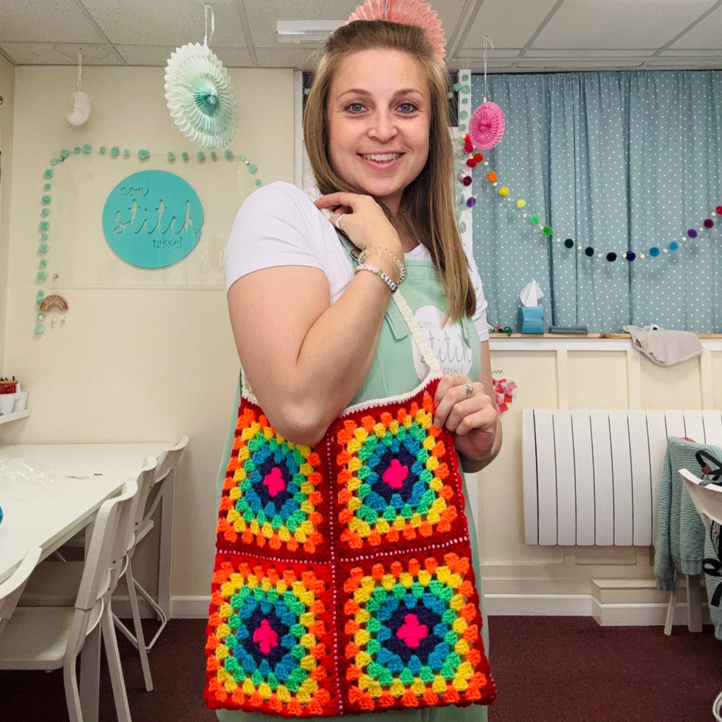 emma at pom stitch tassel holding crochet bag on arm