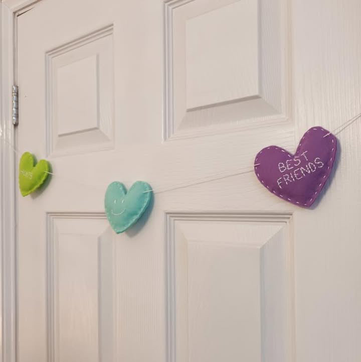 felt heart garland hanging on white door