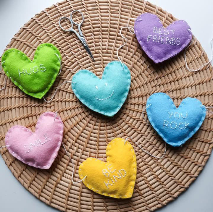 felt hearts embroidered in white stich on rattan place mat.