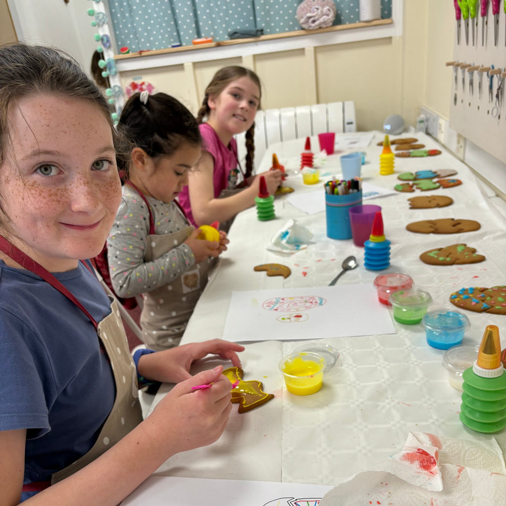 decorating gingerbread biscuits at a gingerbread workshop at pom stitch tassel HQ