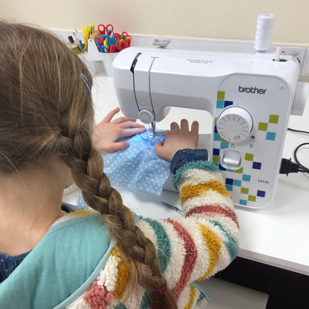 little girl sewing on a Brother sewing machine 