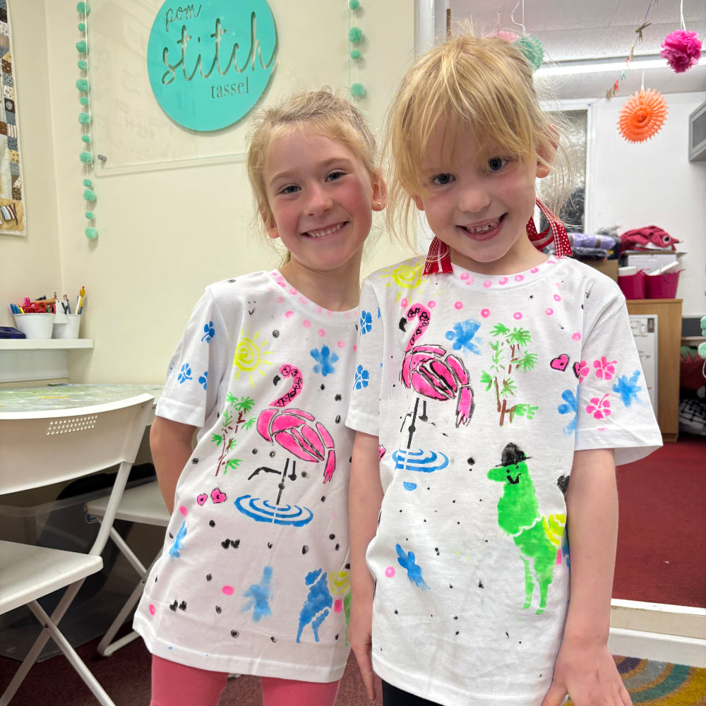 two young blonde girls printing tshirts at our summer festival