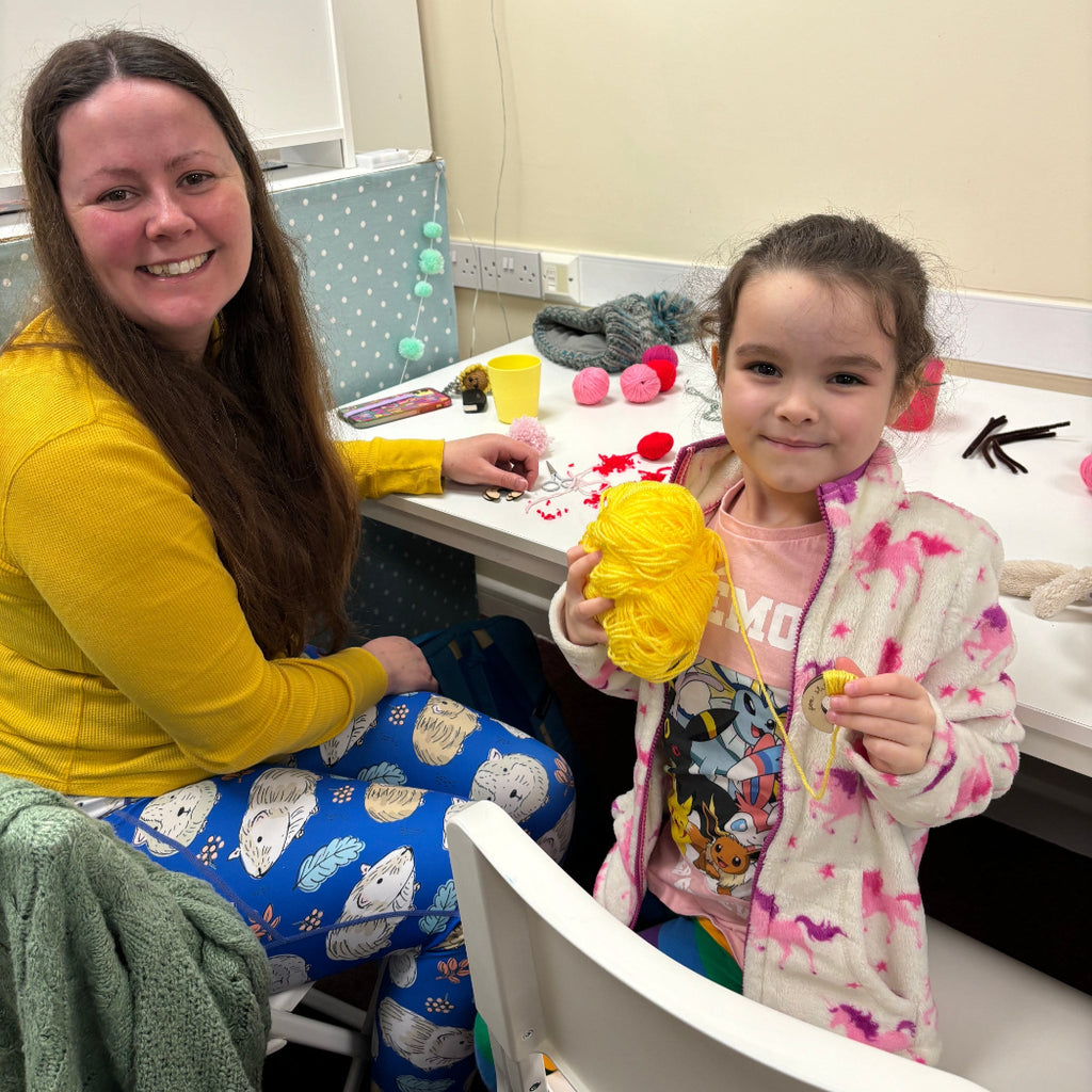 mum and daughter making pom poms with yellow wool at pom stitch tassel hq