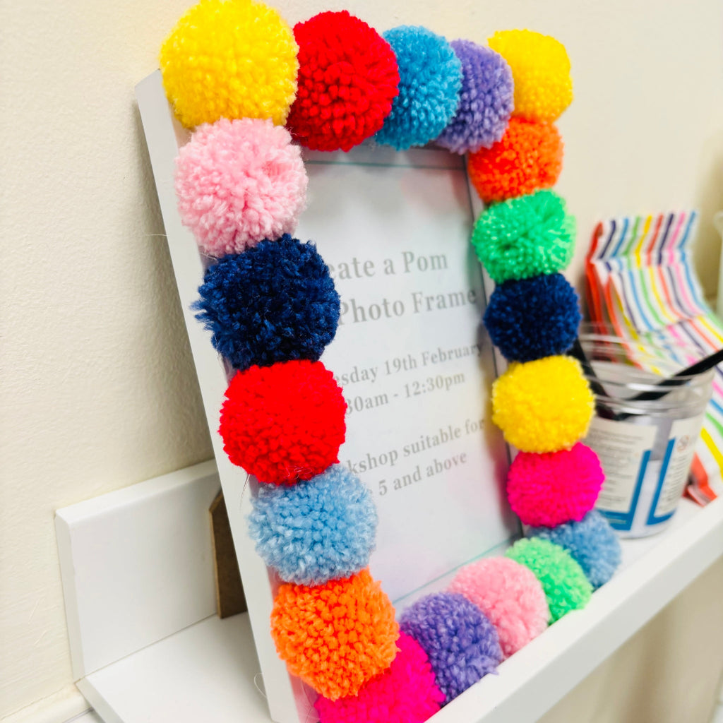 pom pom photo frame on white shelf