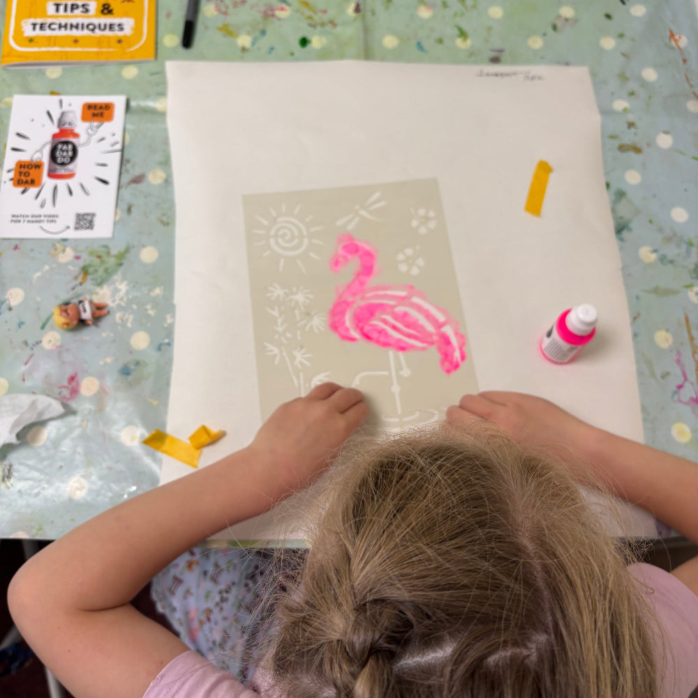 printing a flamingo with stencils onto a table