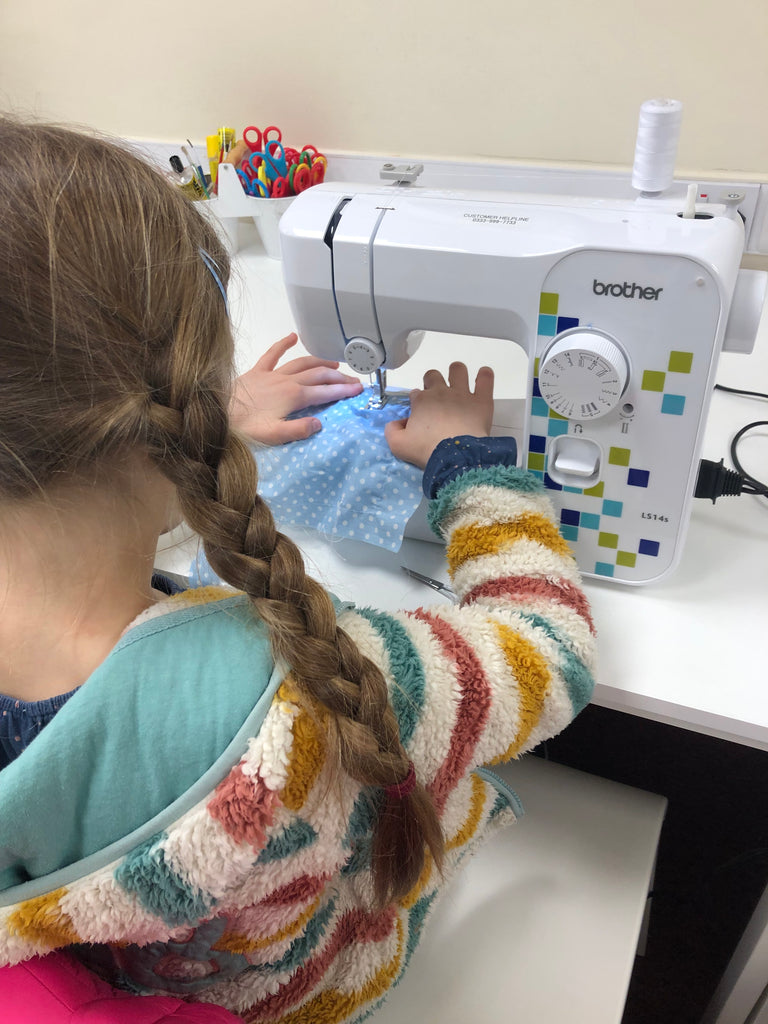 little girl sewing in pom stitch tassel's stitch club