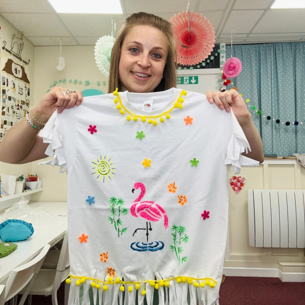 emma holding up a designed tshirt print made at pom stitch tassel HQ